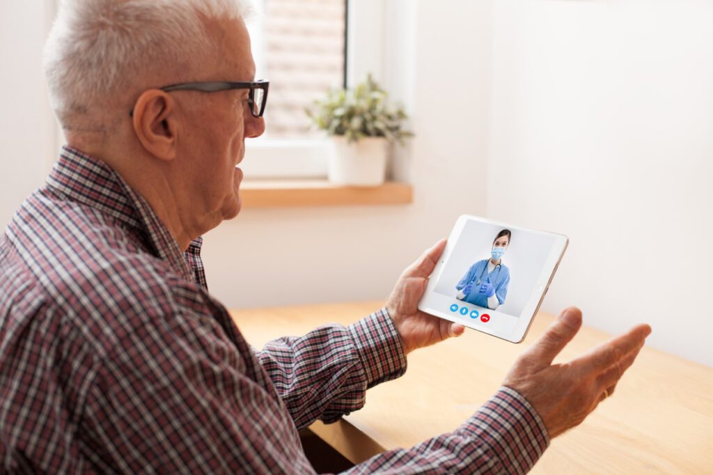 Senior talking to doctor on tablet during the pandemic