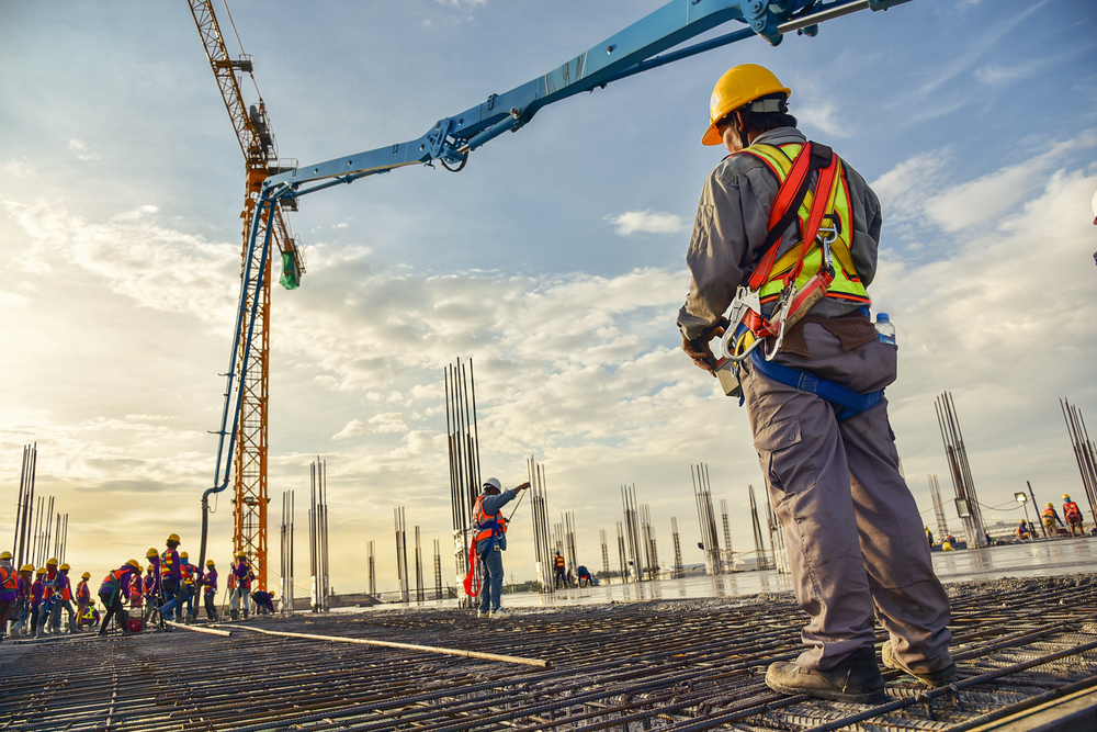 Worker on a construction site manipulating crane