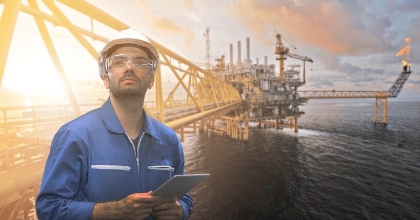 field worker in front of oil platform